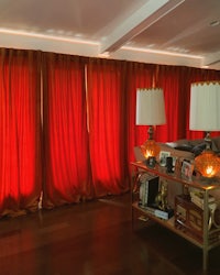 a living room with red curtains